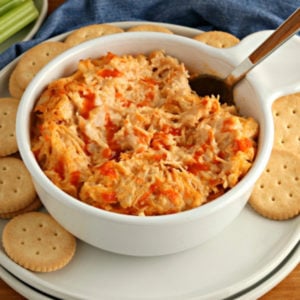 gluten-free appetizer recipe of buffalo chicken dip in a white bowl with crackers