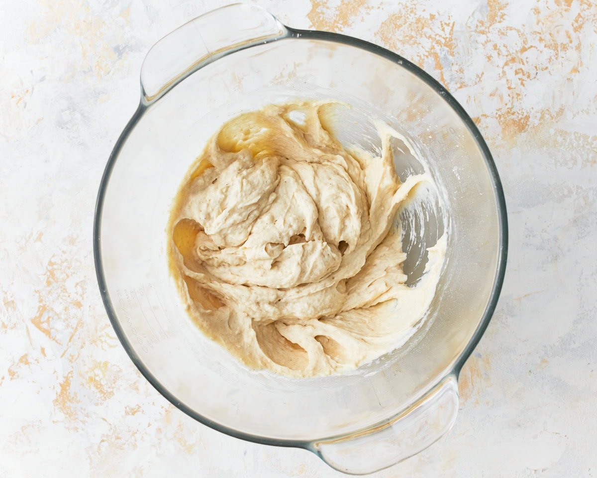 wet gluten-free focaccia dough in a glass bowl.