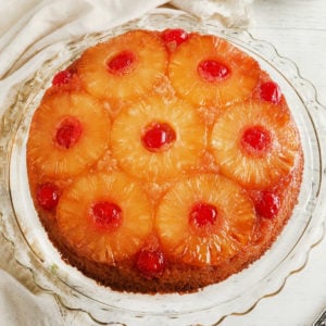 gluten-free pineapple upside down cake on a glass cake plate