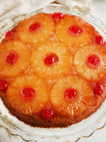 gluten-free pineapple upside down cake on a glass cake plate