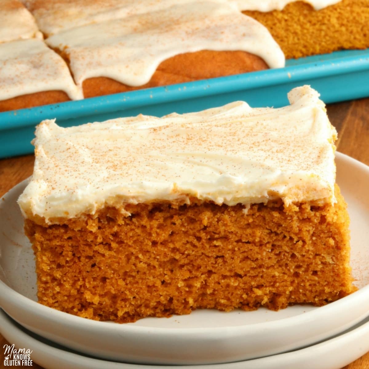 gluten-free pumpkin bar slice on a white plate with the bars in the background