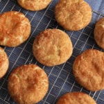 gluten-free snickerdoodle cookies on a sliver cooling rack on top of a blue kitchen towel