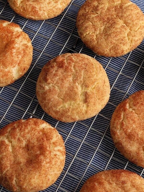 gluten-free snickerdoodle cookies on a sliver cooling rack on top of a blue kitchen towel