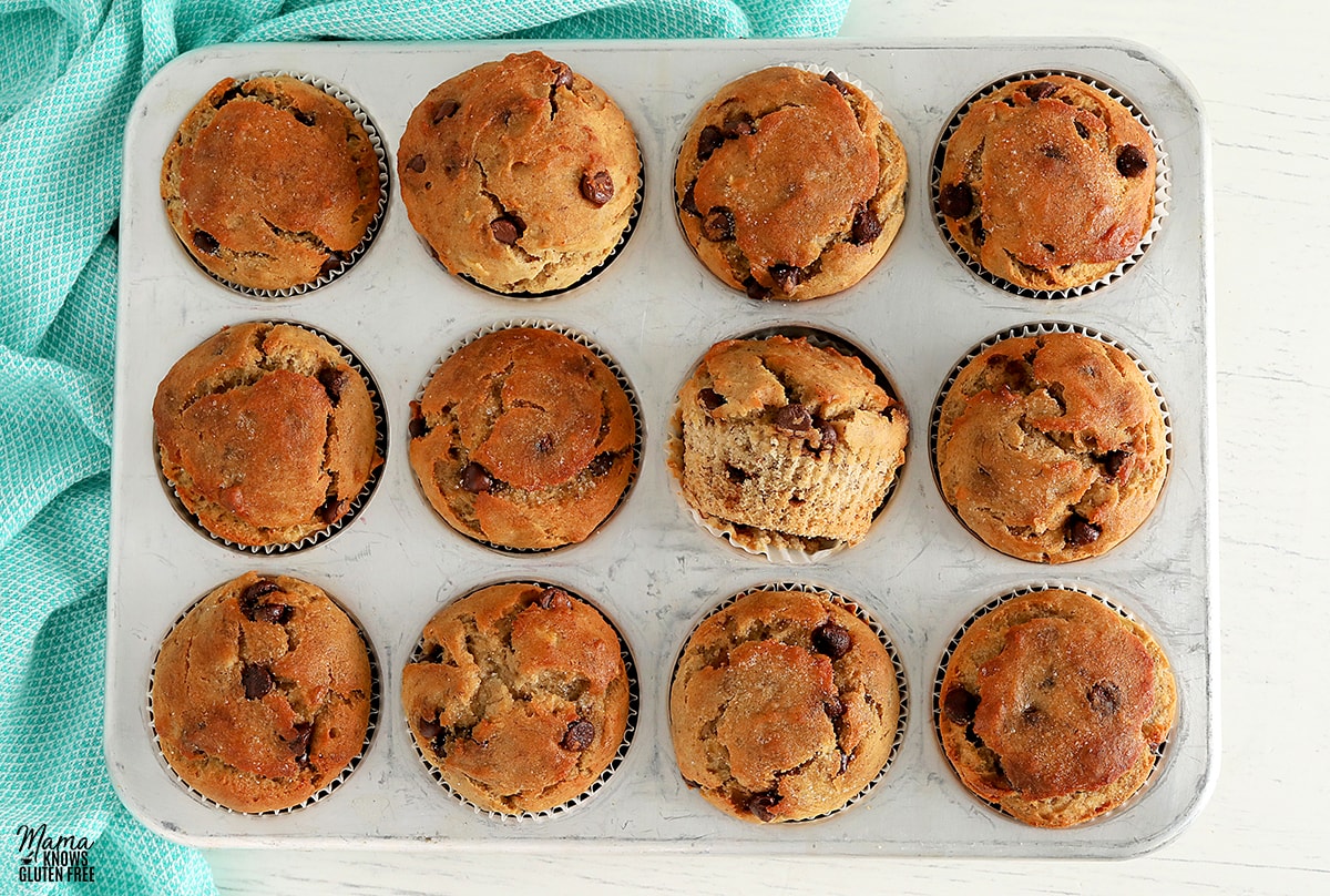 gluten-free banana muffins in a sliver muffin pan with a blue kitchen towel