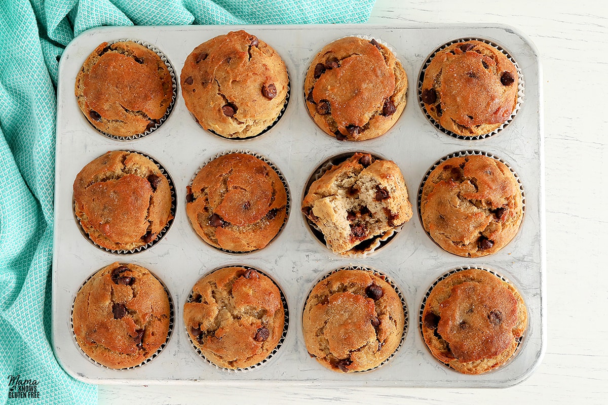 gluten-free banana chocolate chip muffins in a sliver muffin pan with a blue kitchen towel.