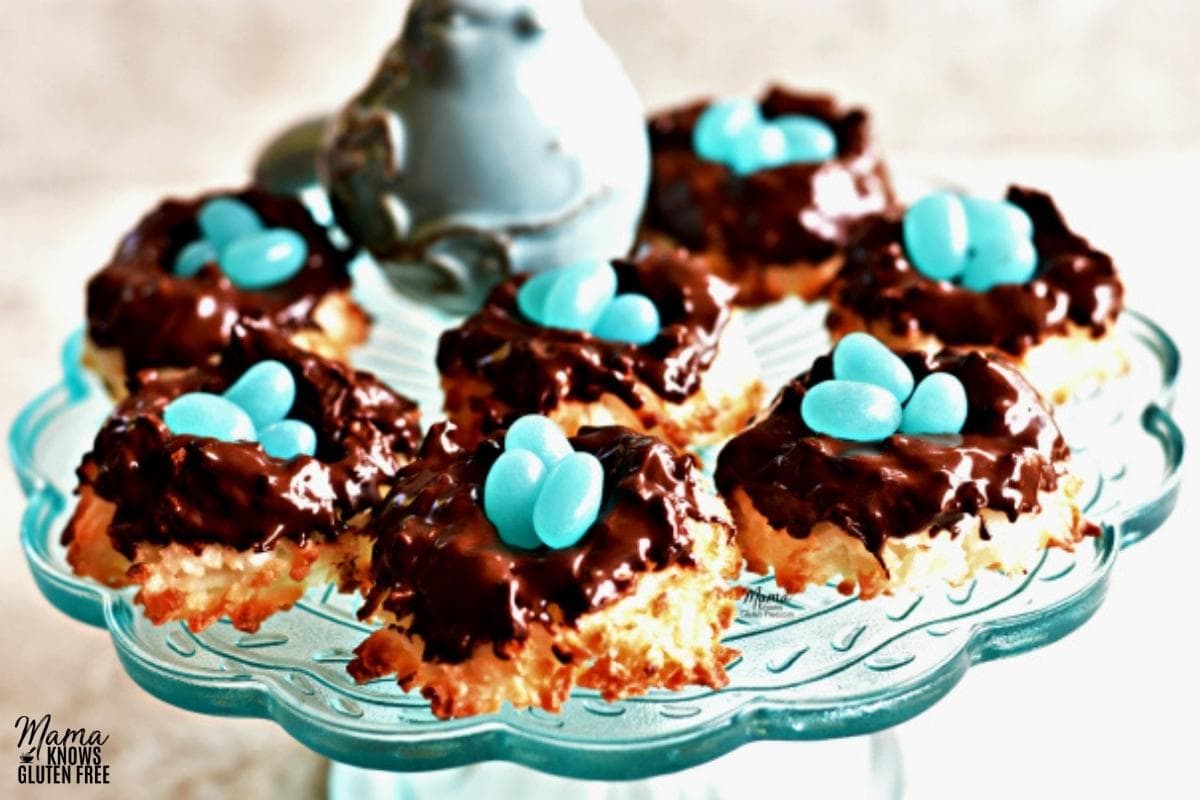 gluten-free coconut macaroon nest cookies on a blue cake plate with a blue bird figurine