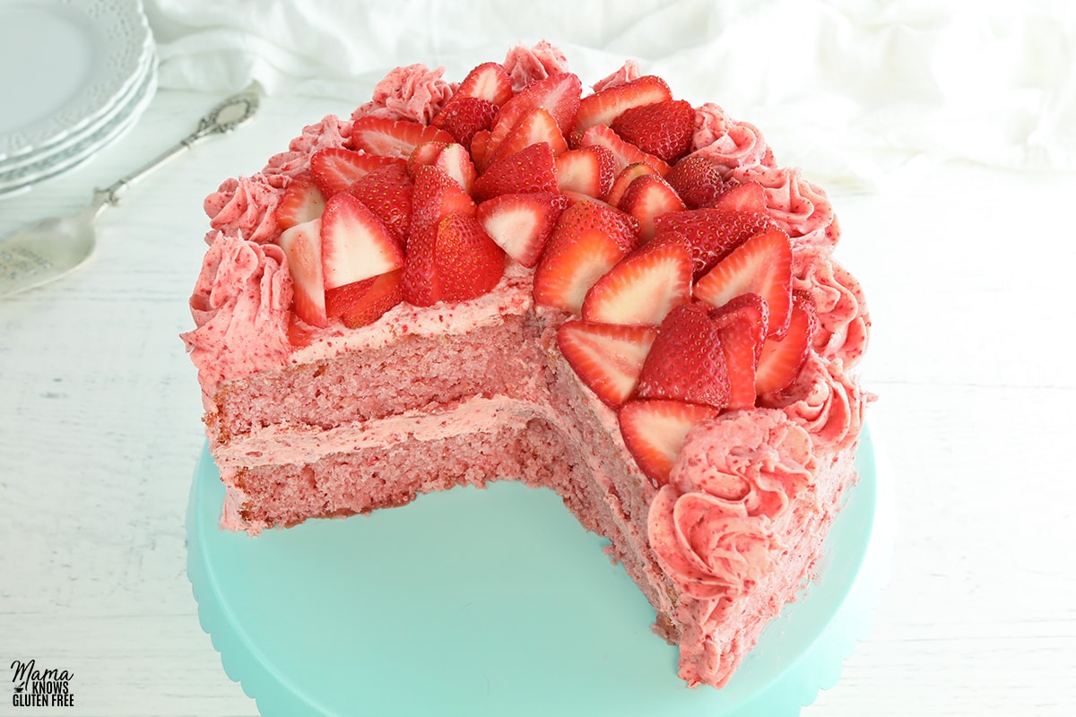 gluten-free strawberry cake sliced on a blue cake stand