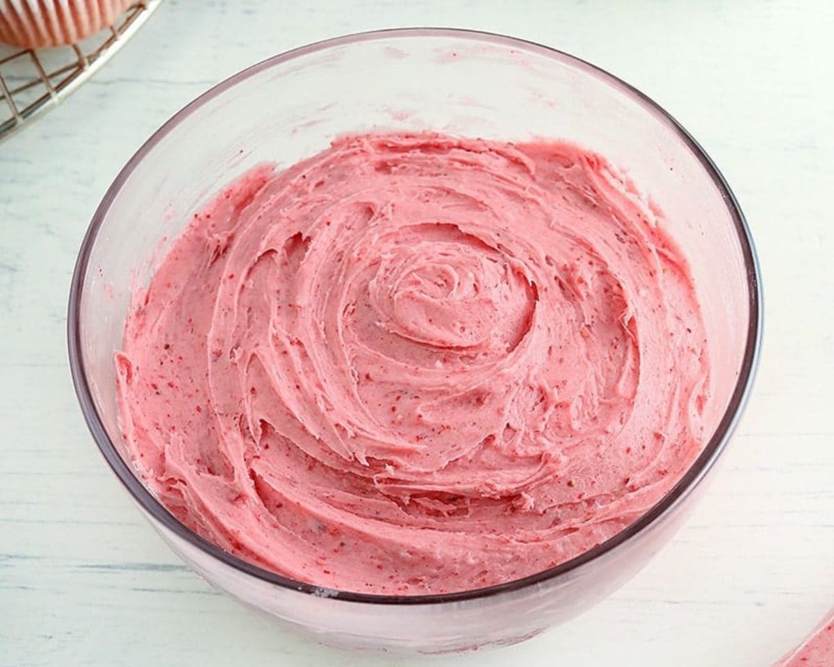 Strawberry frosting in a glass bowl.