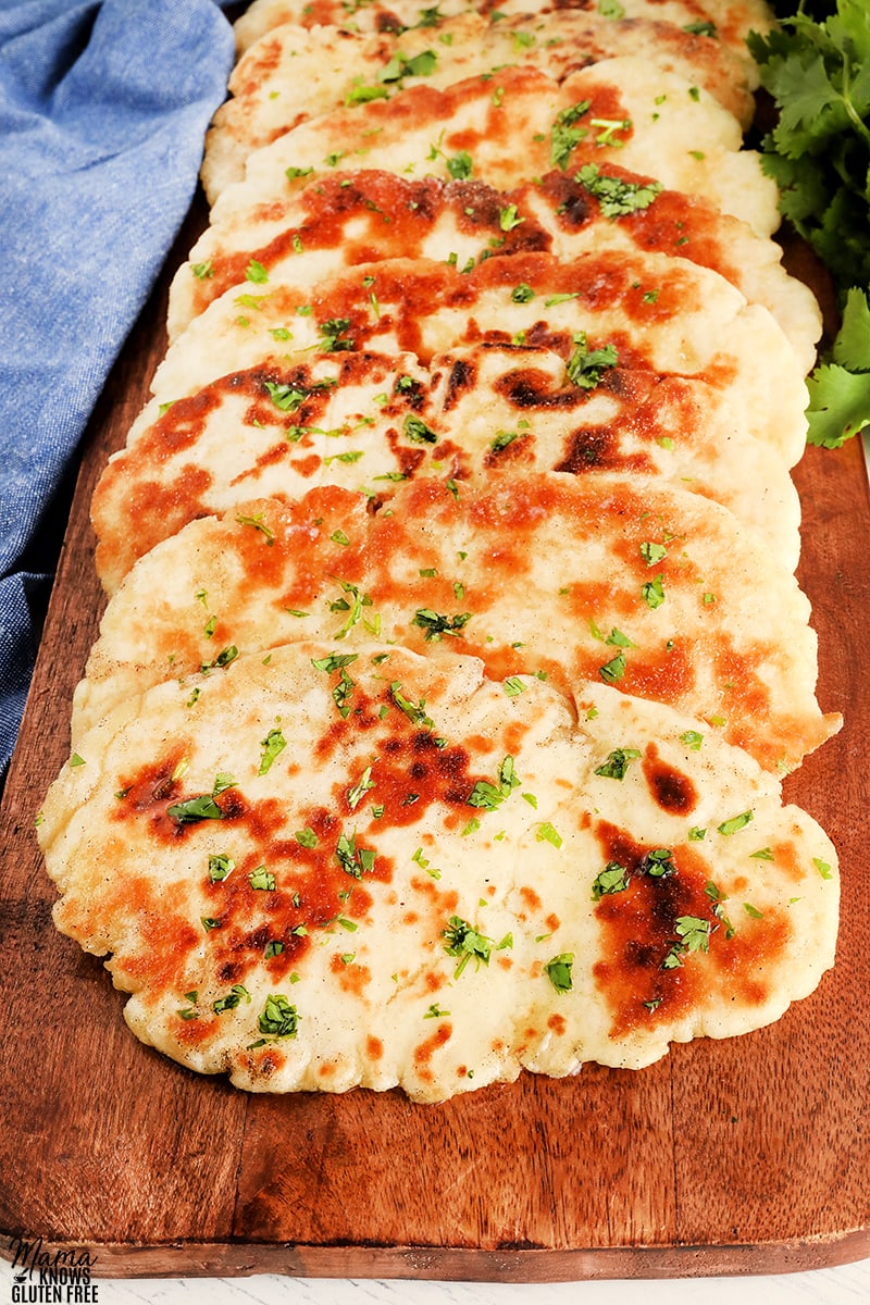gluten-free naan bread on a wooden cutting board with cilantro
