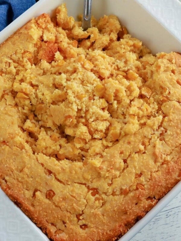 gluten-free corn casserole in a white baking dish with a spoon