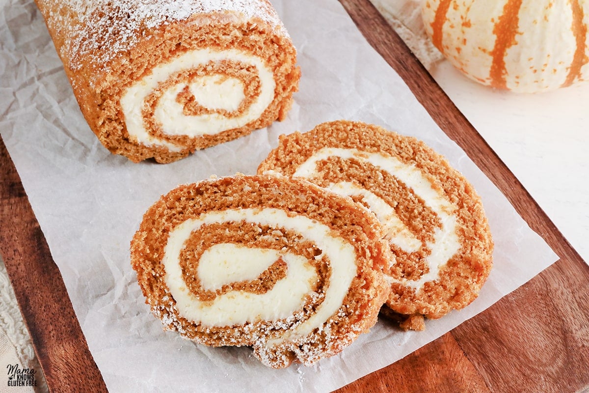 gluten-free pumpkin roll sliced on a wood cutting board