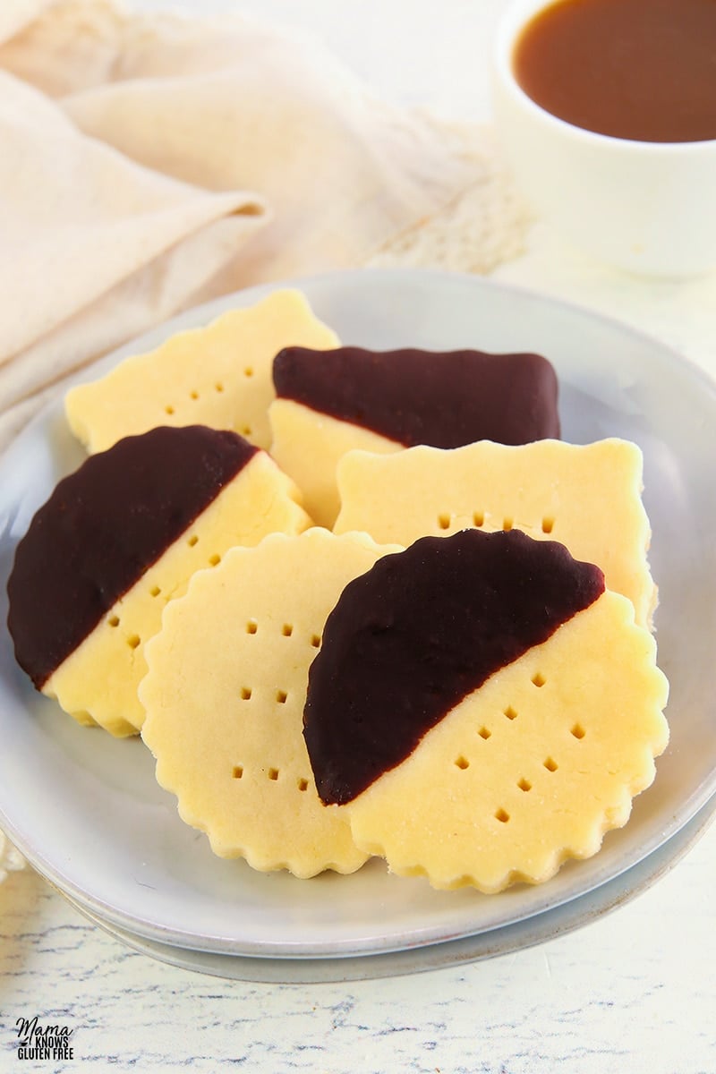 gluten-free shortbread cookies on a white plate with a coffee cup in the background