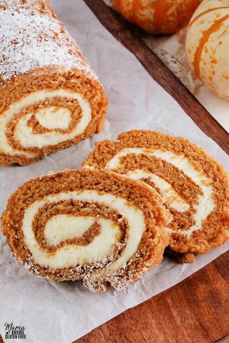 gluten-free pumpkin roll sliced on a brown cutting board