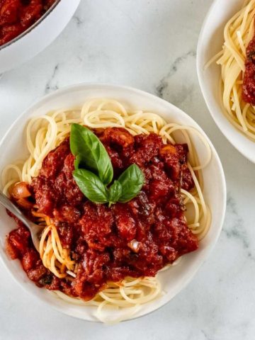 gluten-free spaghetti sauce over pasta in white bowls