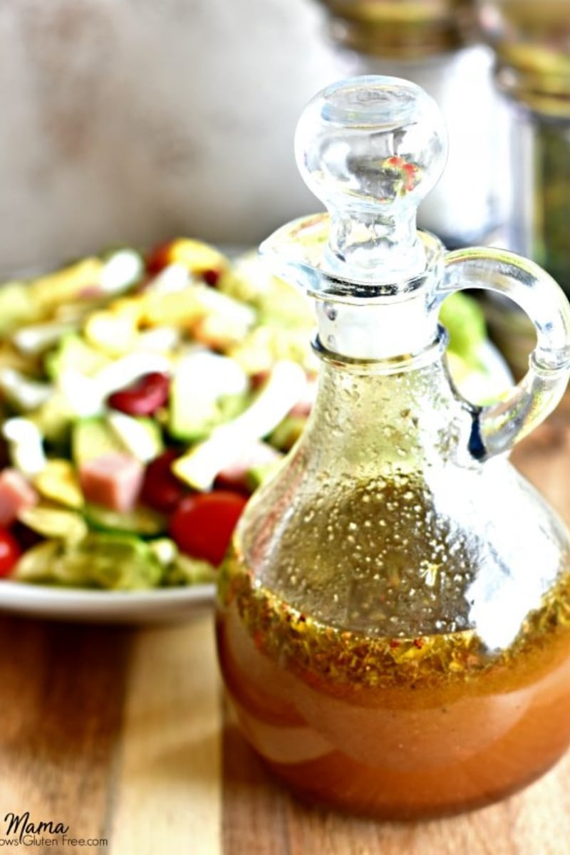 gluten-free balsamic dressing in a glass bottle with a salad in the background