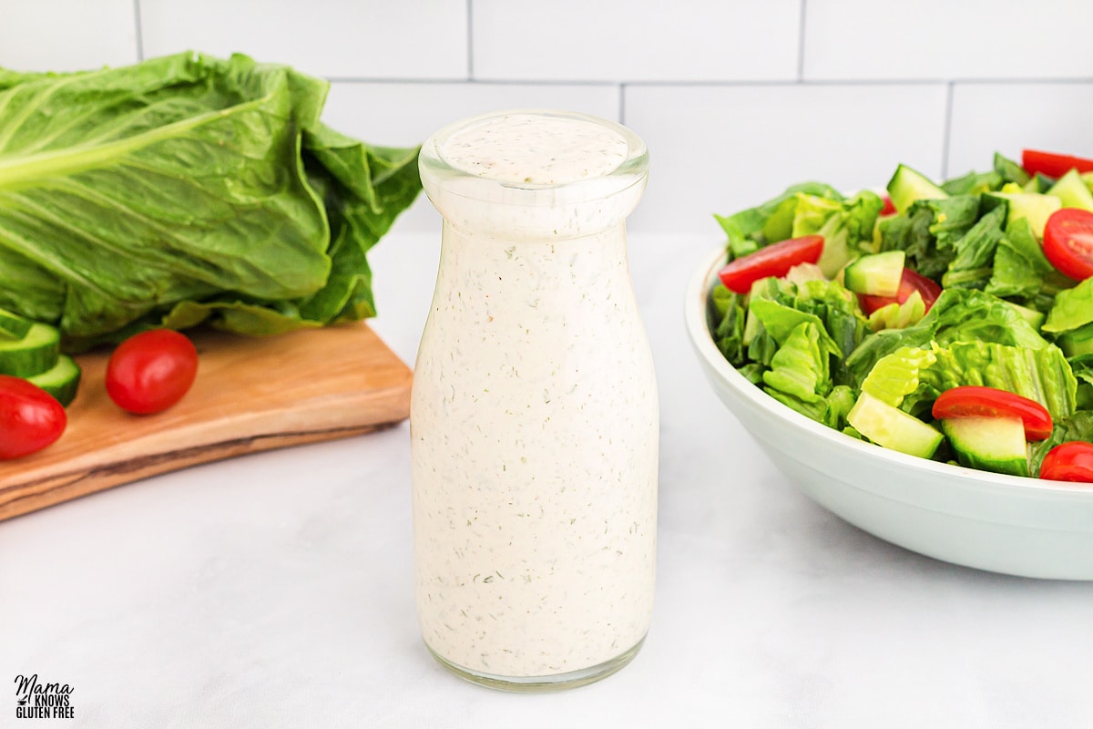 dairy-free ranch dressing in a bottle with a salad in the backgorund