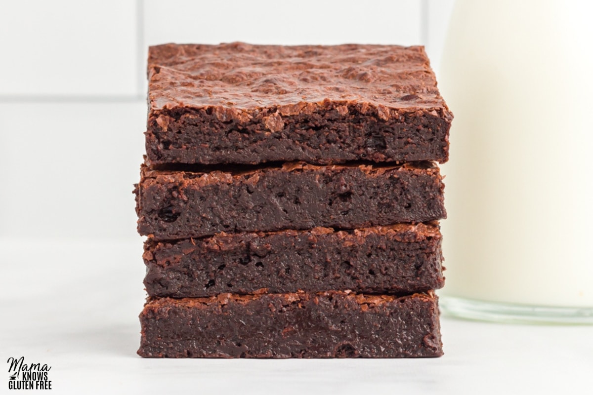 flourless brownies stacked on top of each other with a white background