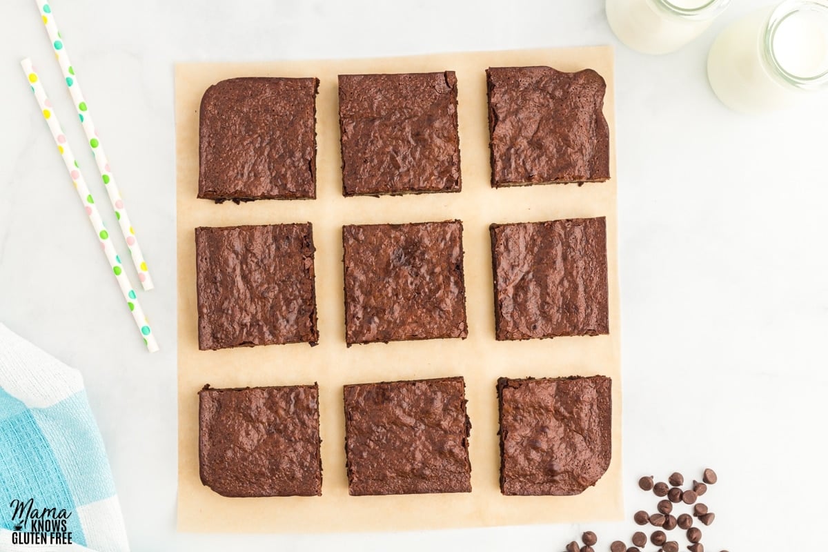 flourless brownies on a cutting board with milk and chocolate chips in the background