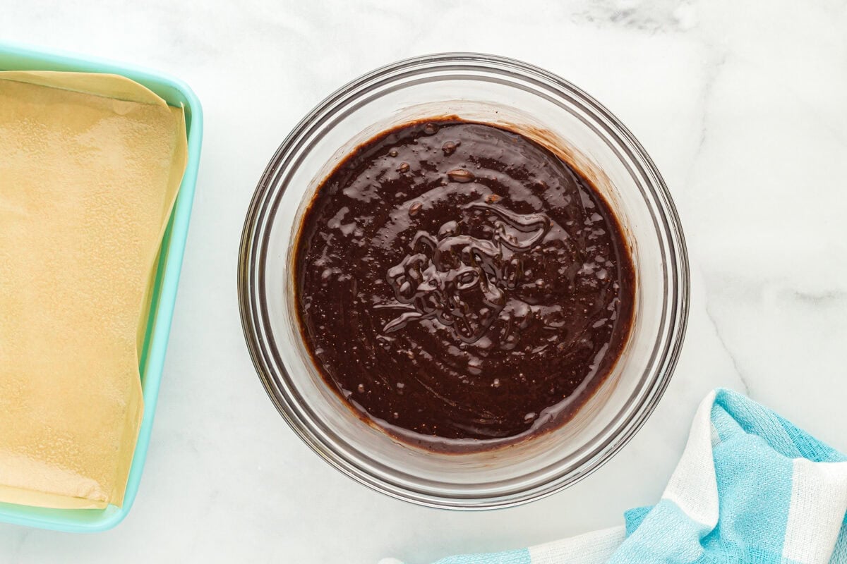 Batter for flourless brownies in a glass mixing bowl.