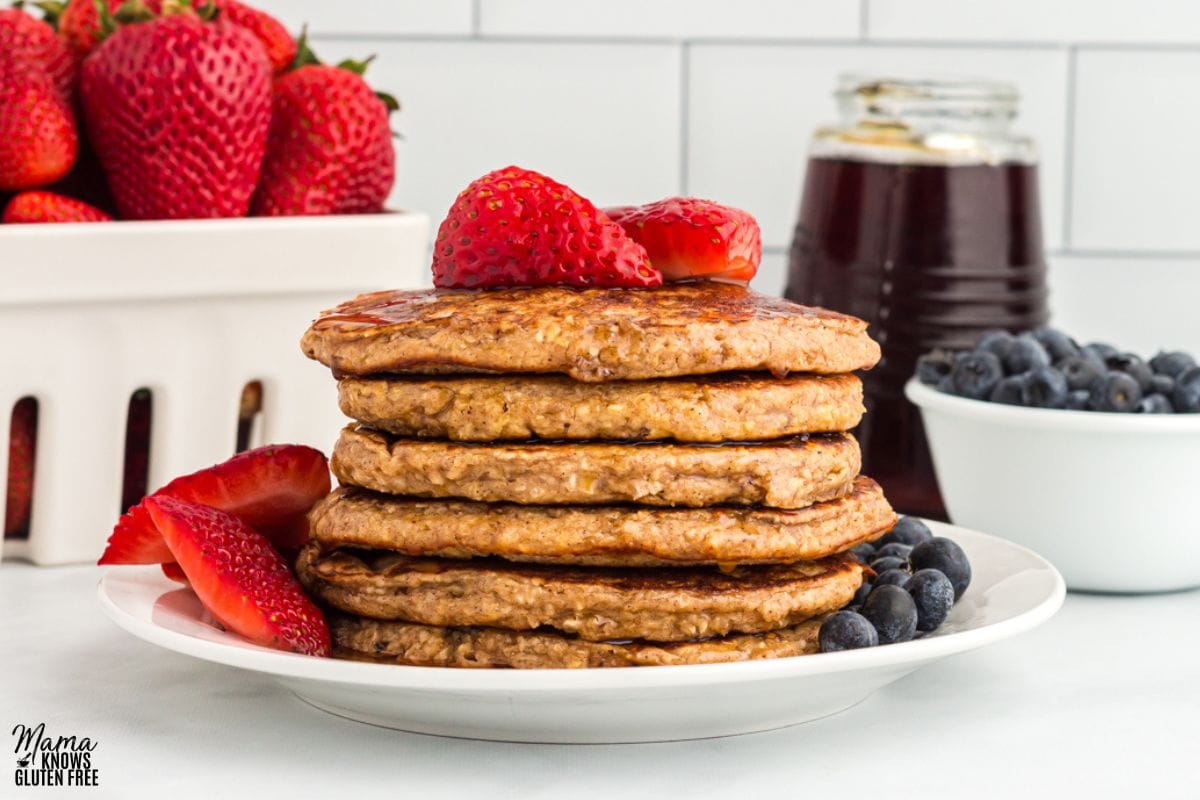 Oatmeal Pancakes on plate topped with strawberries and blueberries