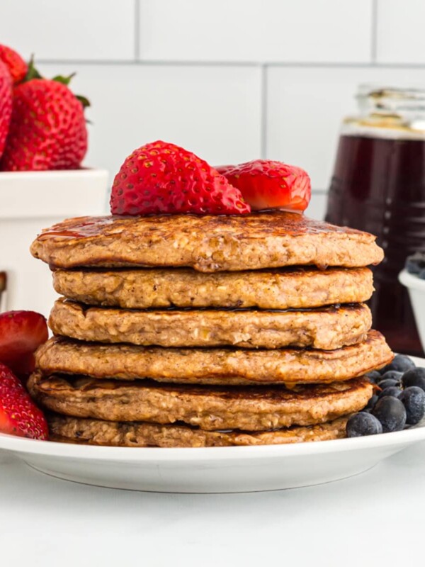 Oatmeal Pancakes on plate with fresh strawberries and blueberries