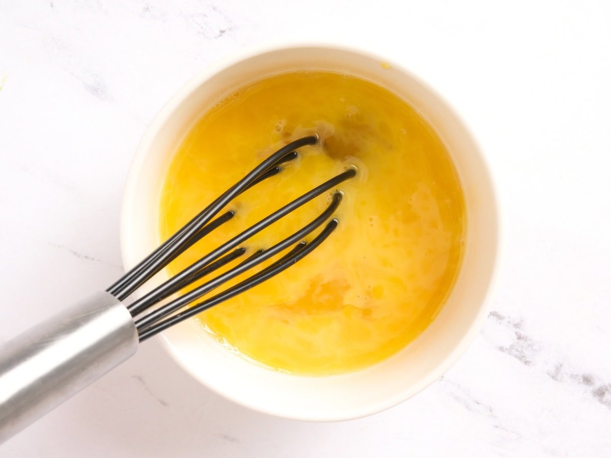 Whisked eggs in a white bowl, ready to mix into the almond flour pizza dough