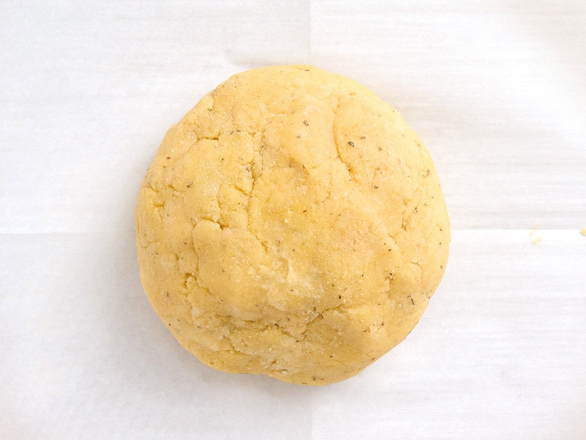 Almond flour pizza dough formed into a smooth ball on parchment paper