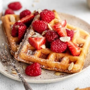 Almond flour pancakes with strawberries and almond flakes on top.