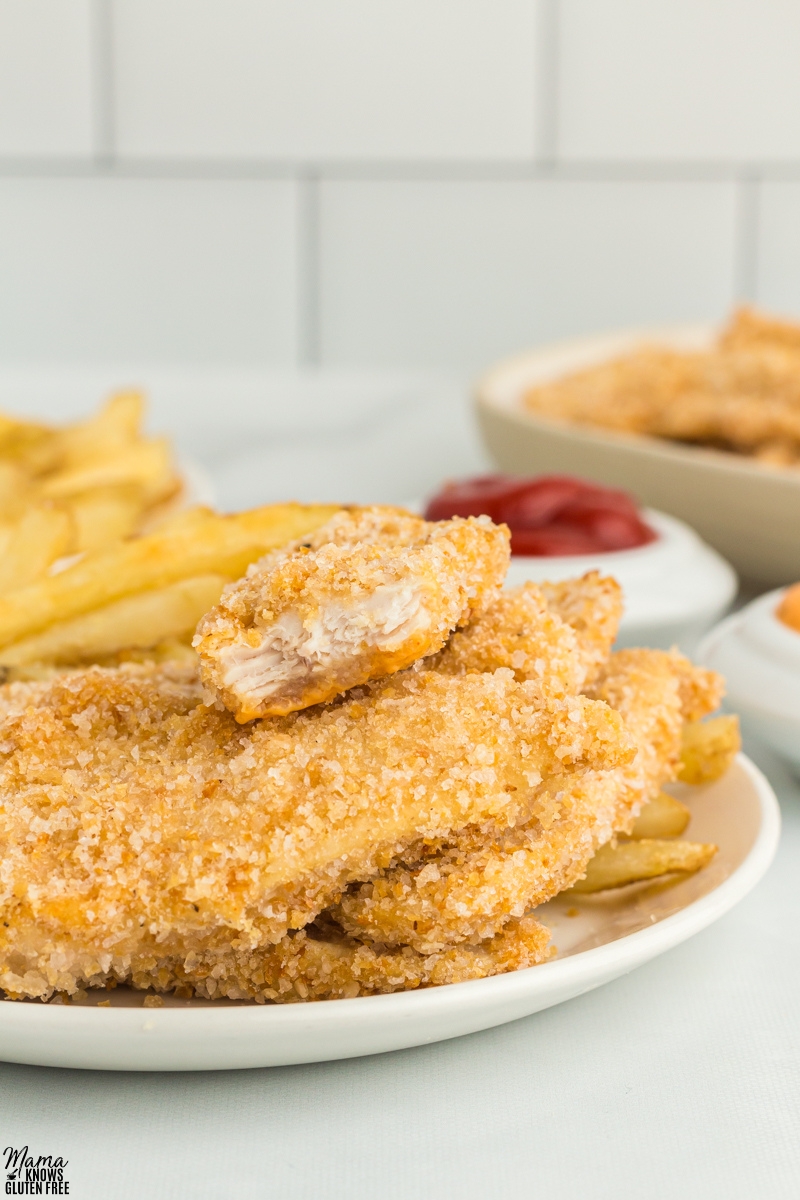 Close-up of insider of Gluten-Free Chicken Tender piled on top of other pieces of chicken.