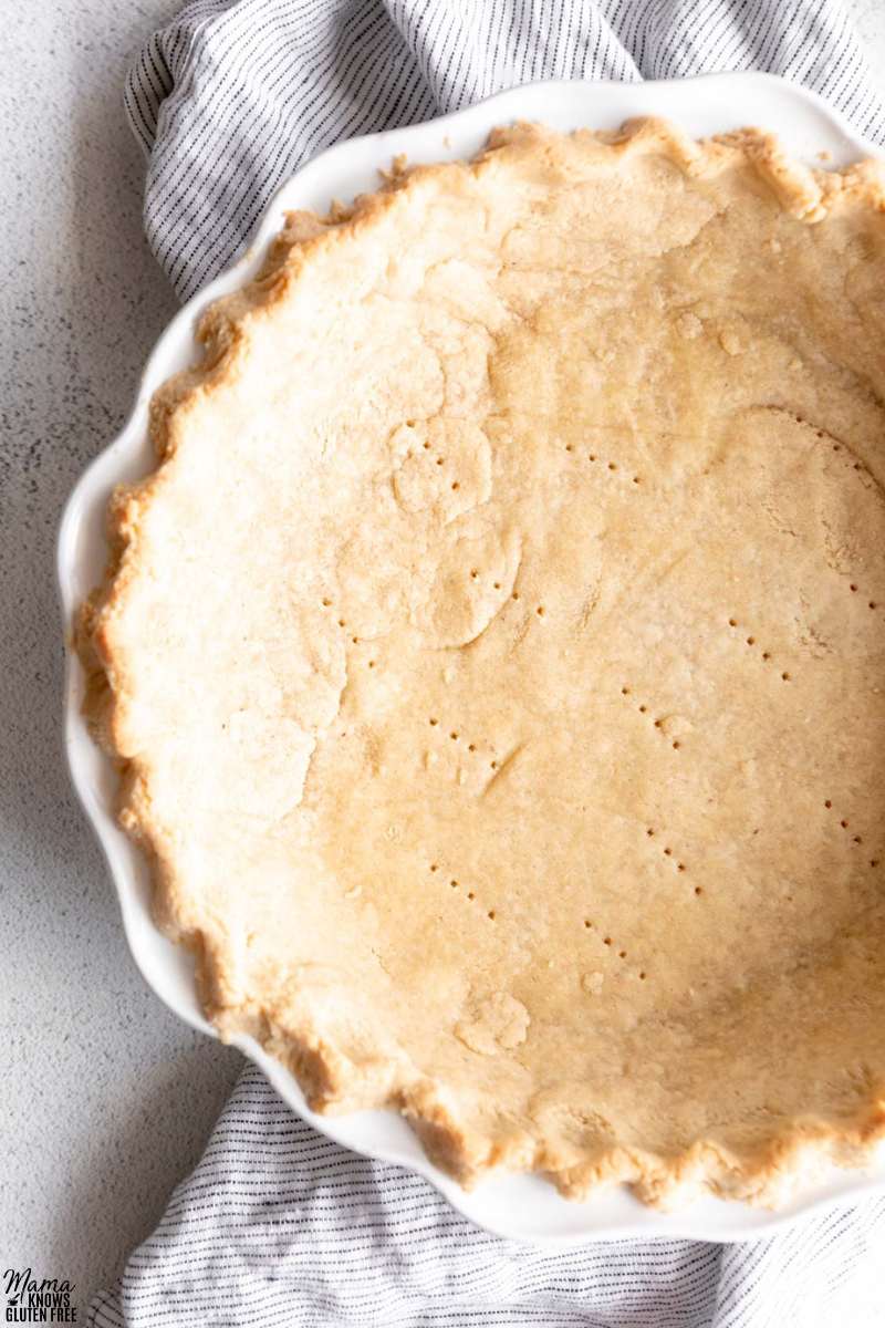 Close up shot of Gluten-Free Almond Flour Pie Crust baked in white pie plate.