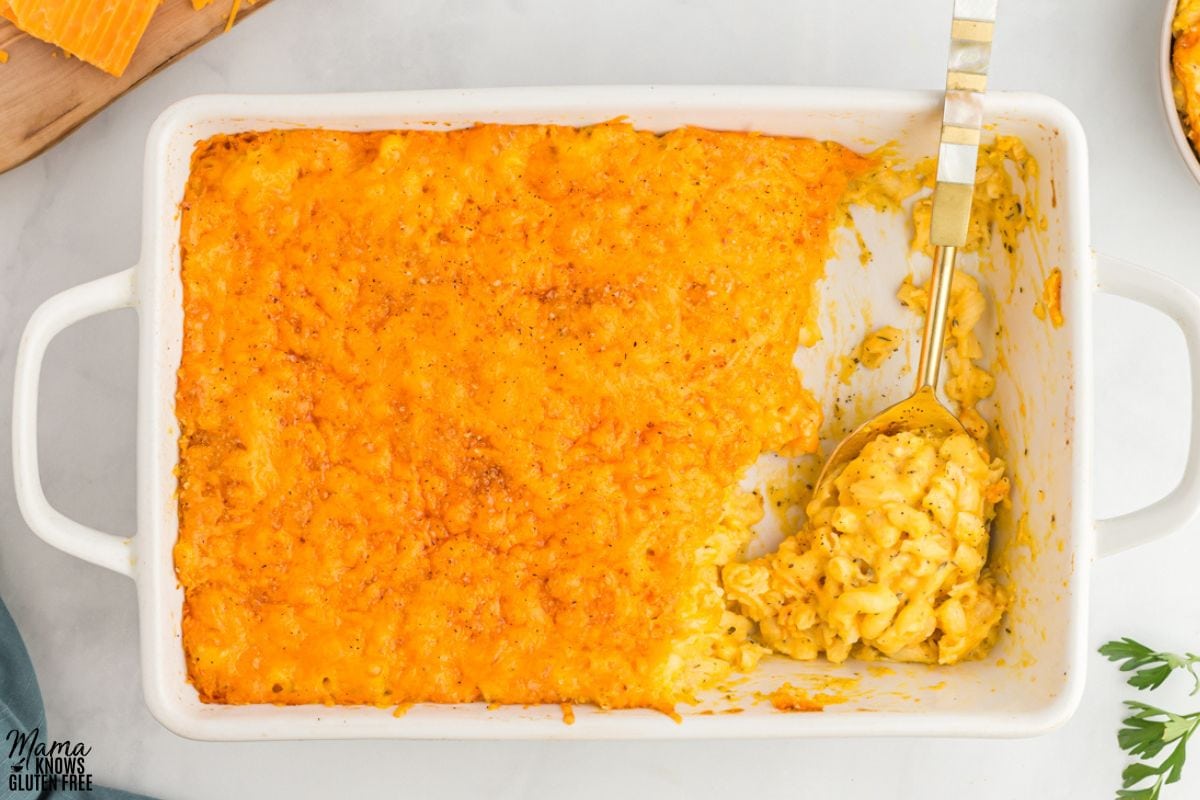 Gluten-Free Butternut Squash Mac and Cheese baked in white casserole pan scooped with large spoon