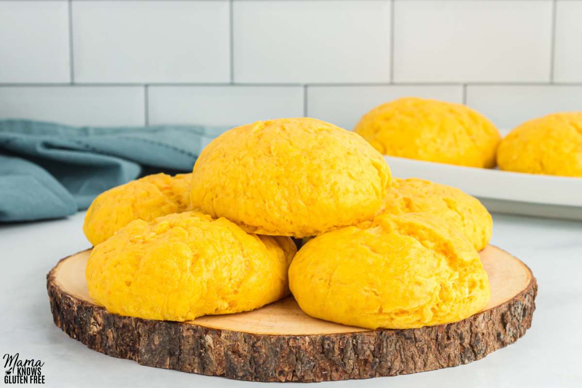 Five Gluten-Free Sweet Potato Rolls placed on wooden serving platter.