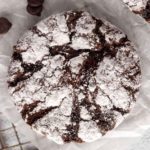 gluten-free chocolate crinkle cookies on white parchment paper