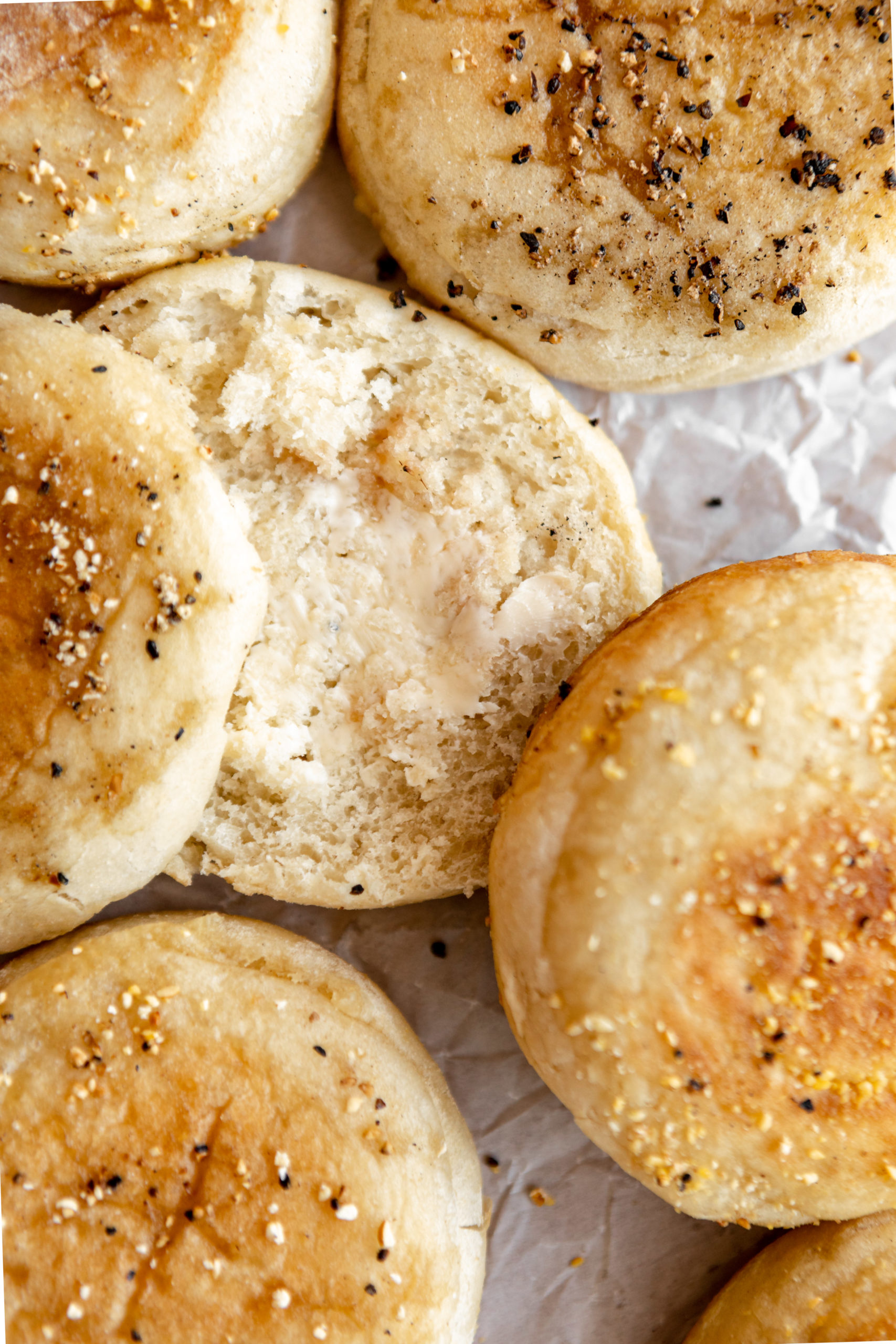gluten-free english muffin split open and spread with melted butter.