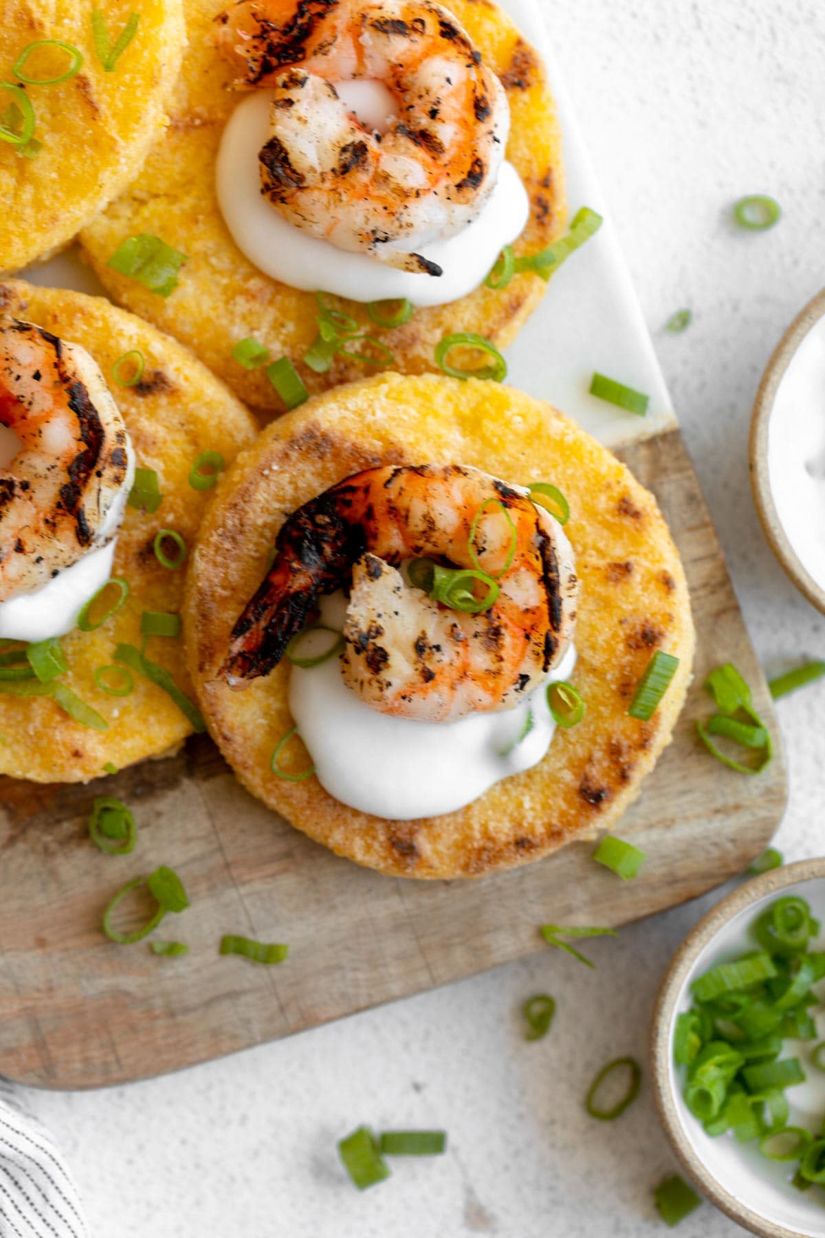 grit cakes topped with white sauce and shrimp.