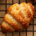 gluten-free croissant om a black cooing rack