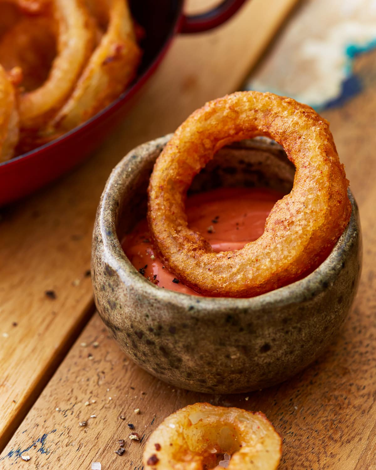 a gluten free onion ring dipped in ketchup.