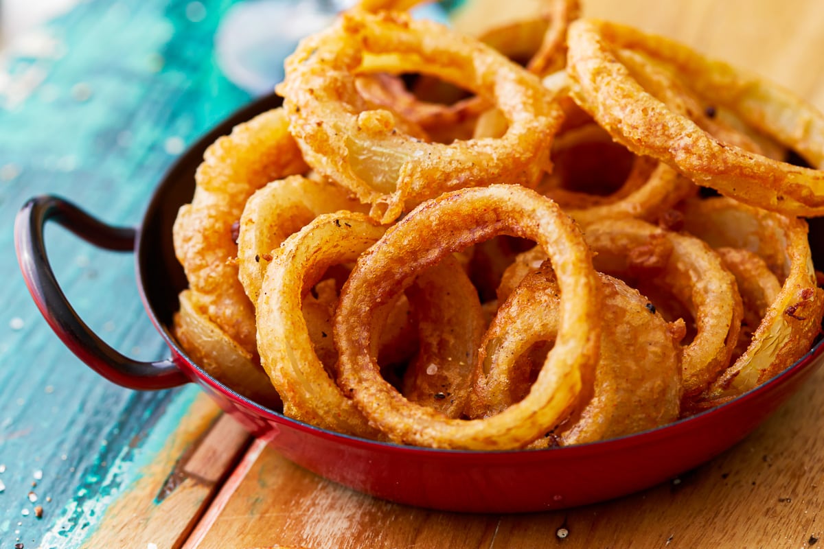 gluten free onion rings in a red cast iron dish.