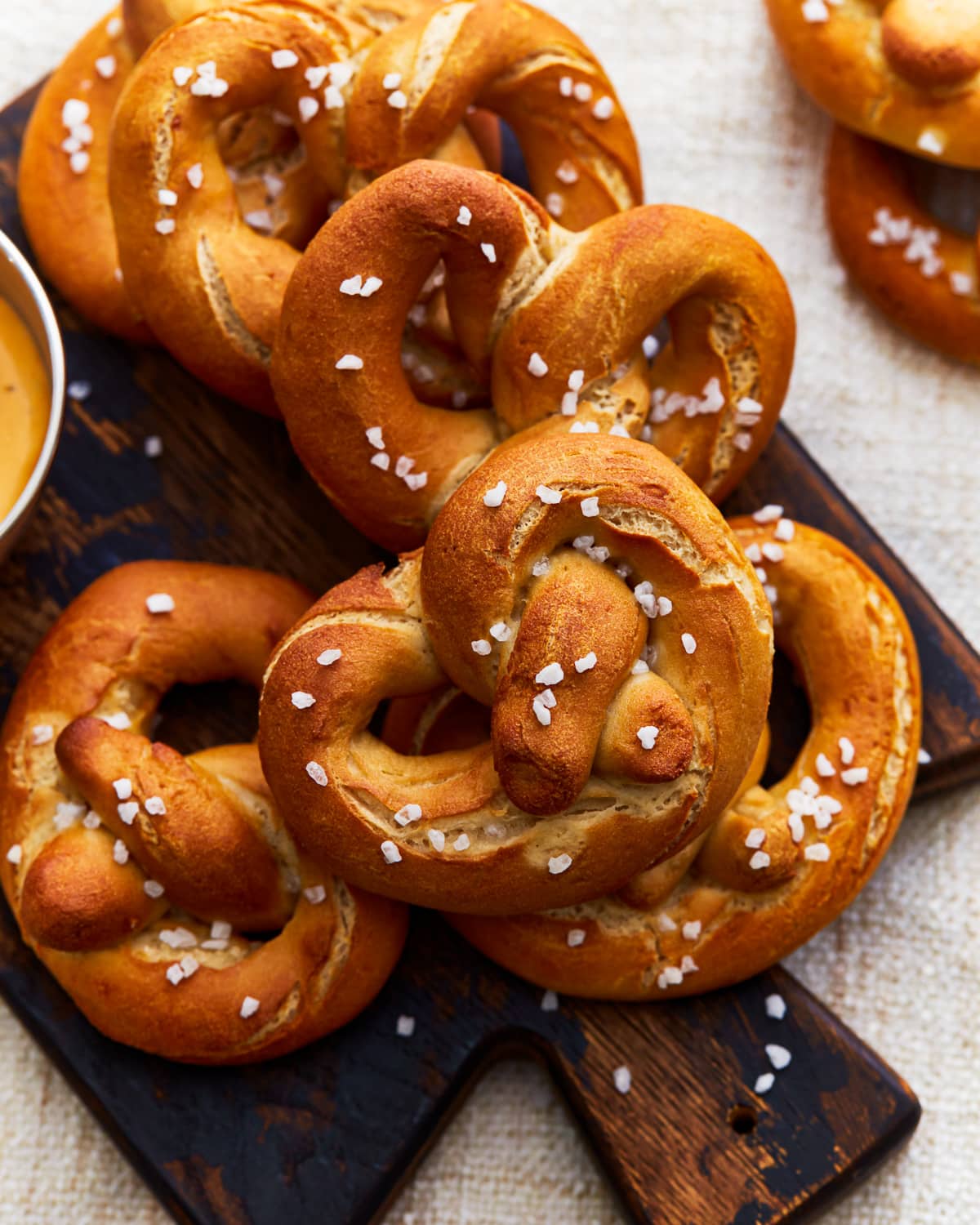 Gluten-free soft pretzels on a wooden cutting board.