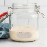 gluten-free sourdough starter in a glass jar with a lid