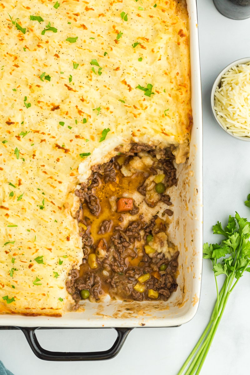gluten free shepherds pie in a baking dish with a portion scooped out.