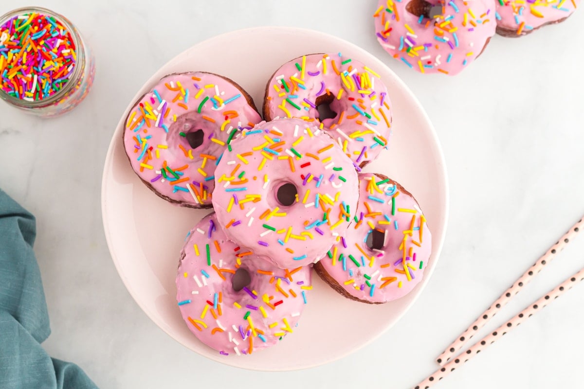 frosted donuts arranged on white plate