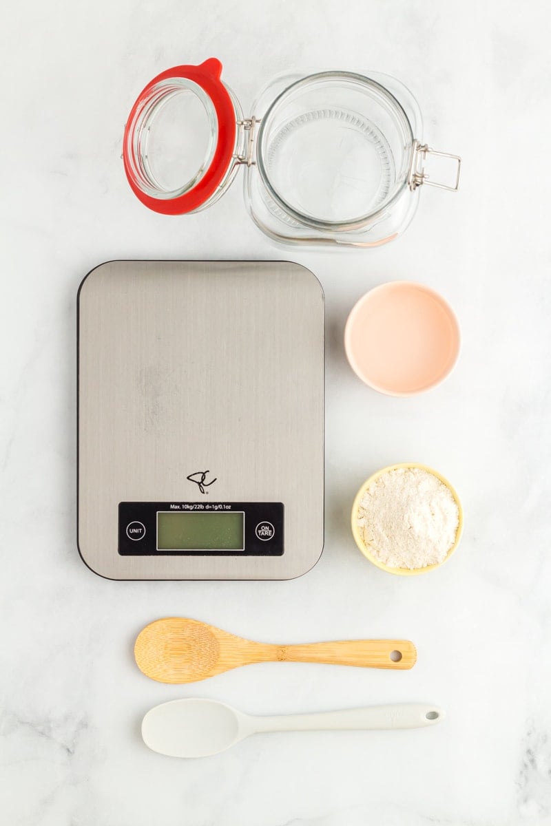 tools for gluten free sourdough starter on a marble counter.