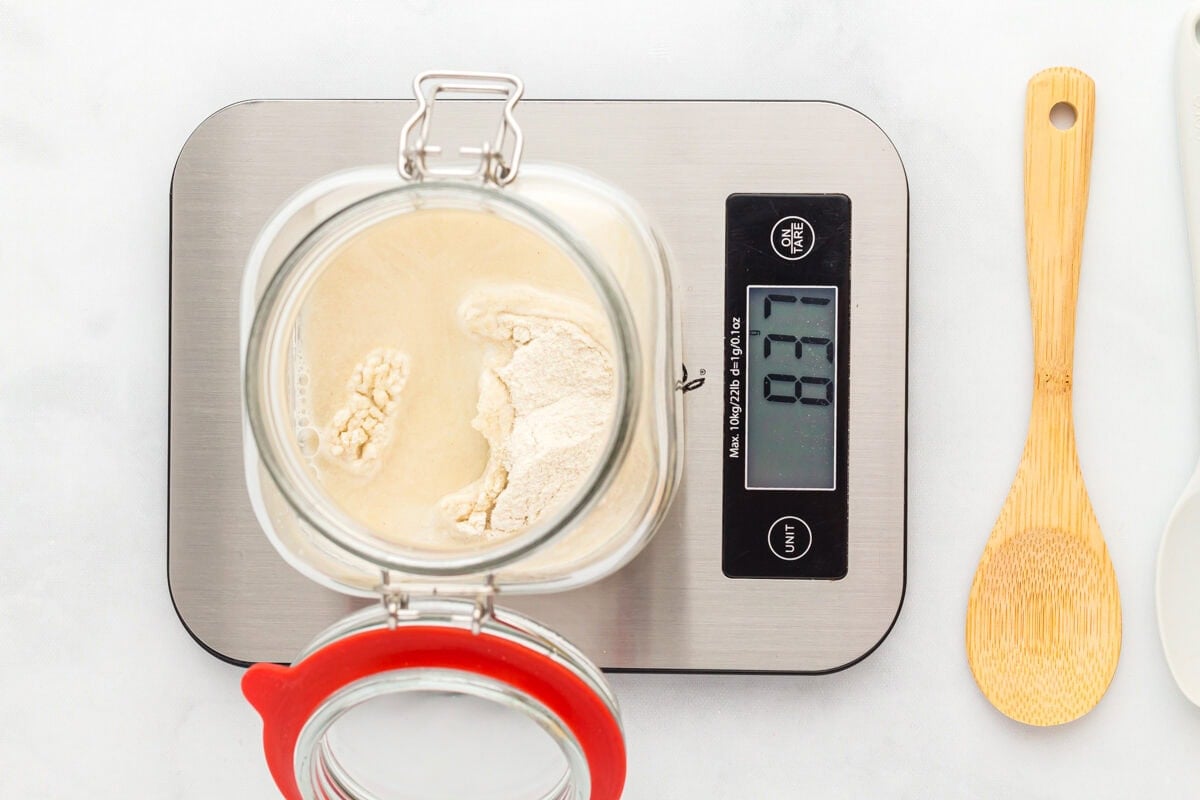 flour and water in a glass jar on a scale that reads 837.