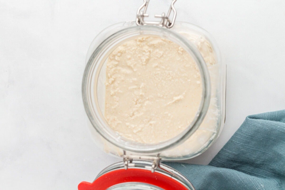 bubbling gluten free sourdough starter in a glass jar.