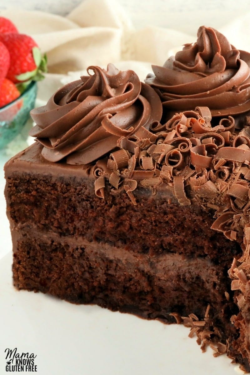 gluten-free chocolate cake sliced on a white cake stand 