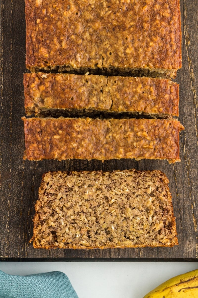 flourless banana bread sliced on a dark brown cutting board