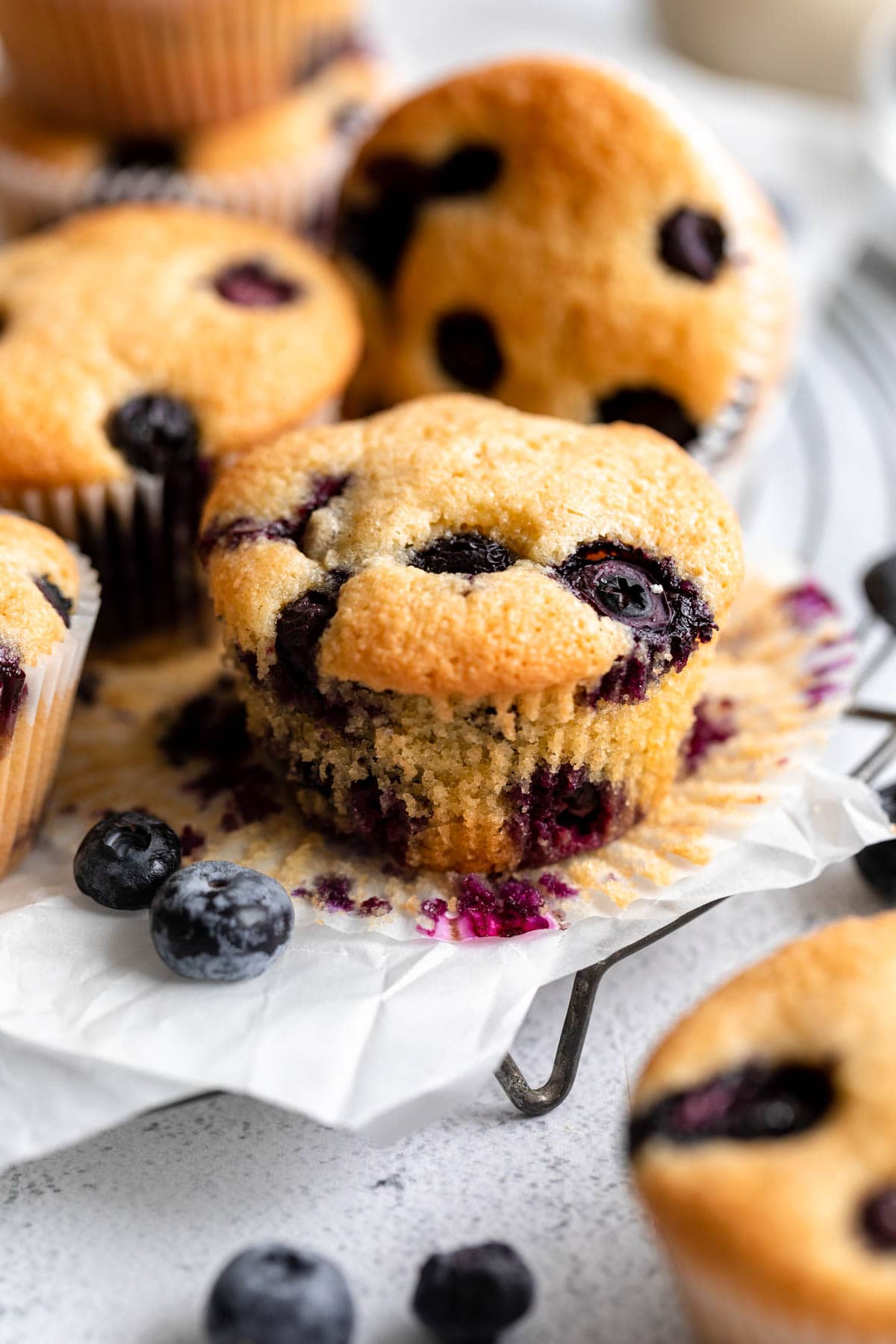 an unwrapped almond flour blueberry muffin on a plate.