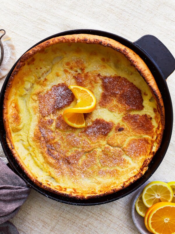 overhead view of a gluten-free dutch baby in a pan with an orange slice.