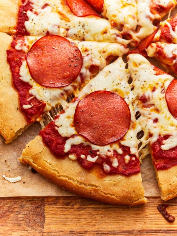 partial overhead view of a sliced gluten-free pepperoni pizza.